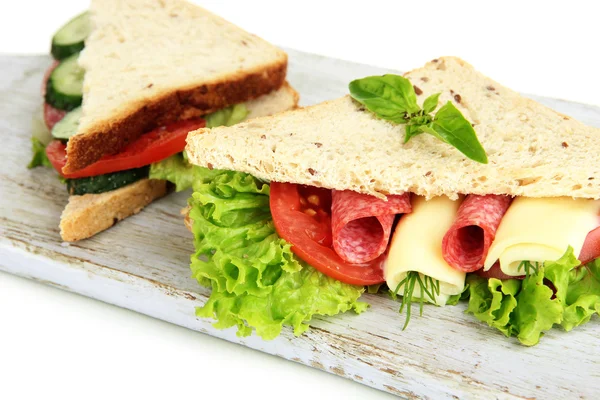 Tasty sandwiches with salami sausage and vegetables on cutting board, isolated on white — Stock Photo, Image