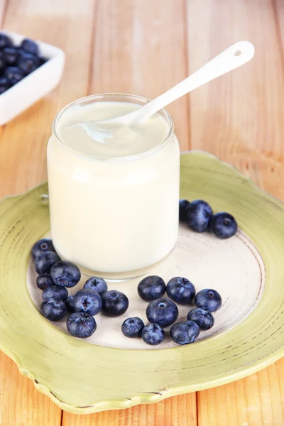 Frischer Joghurt mit Blaubeeren auf Holztisch in Großaufnahme — Stockfoto