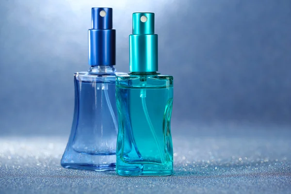 Mulheres perfume em belas garrafas no fundo brilhante — Fotografia de Stock