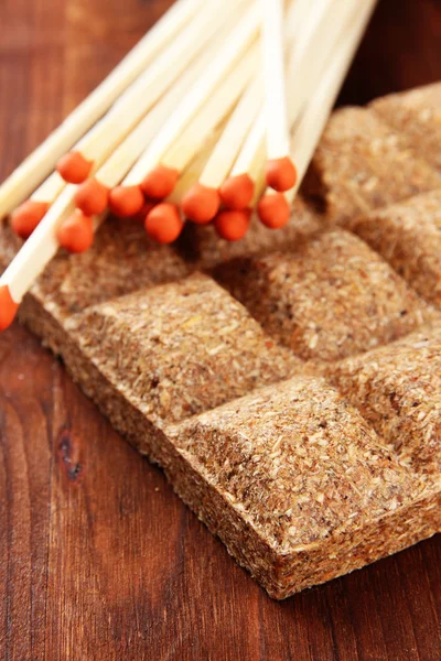 Long matches and dry fuel, on wooden background — Stock Photo, Image