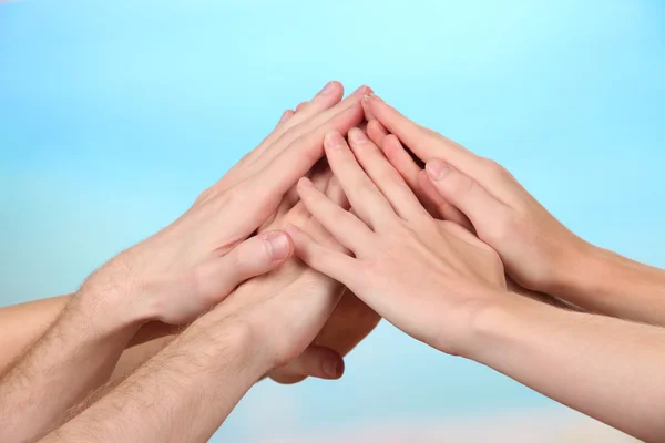 Mani unite su sfondo luminoso. Foto concettuale del lavoro di squadra — Foto Stock