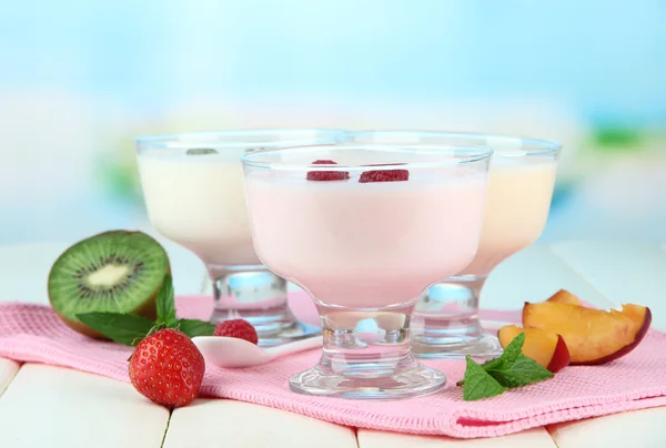 Heerlijke yoghurt met fruit en bessen op tafel op lichte achtergrond — Stockfoto