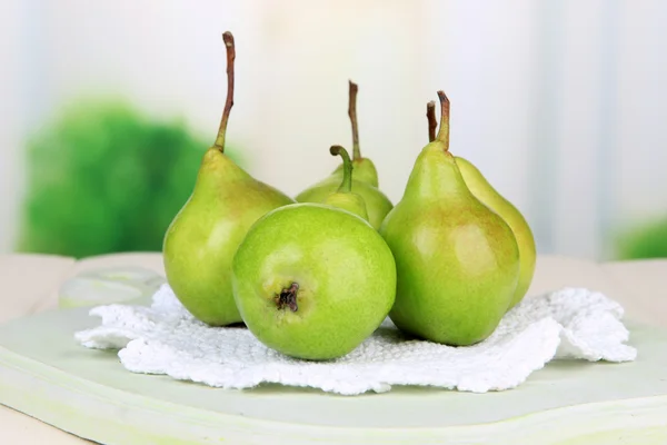 Pears on wooden cutting board, on light background — Stock Photo, Image