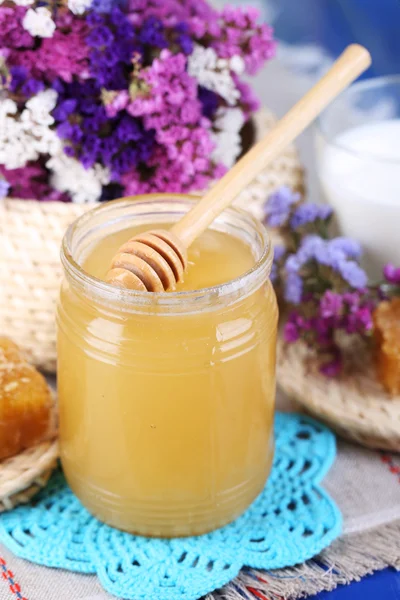 Honing en melk op houten tafel op natuurlijke achtergrond — Stockfoto