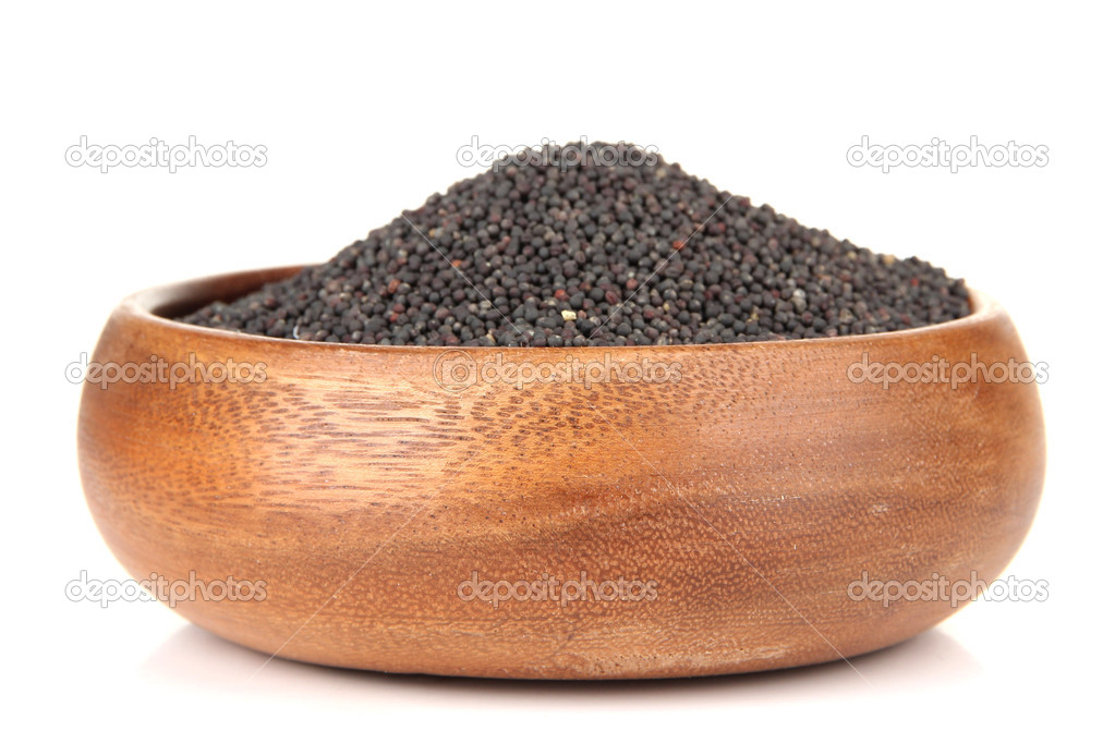 Rape seeds in wooden bowl, isolated on white