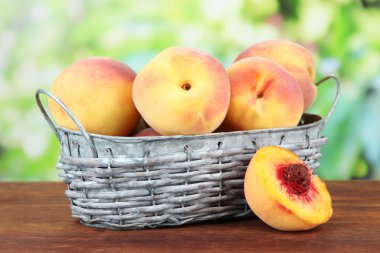 Olgun tatlı şeftali parlak zemin üzerine hasır sepet