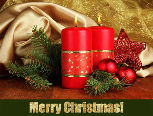 Two candles and christmas decorations, on golden cloth background — Stock Photo, Image