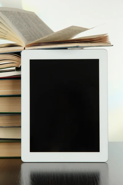Tablet PC- en boeken over lichte achtergrond — Stockfoto