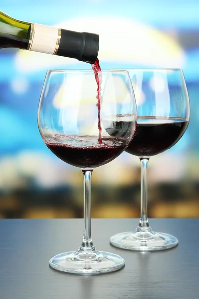 Kırmızı şarap şarap cam, parlak zemin üzerine dökülür — Stok fotoğraf