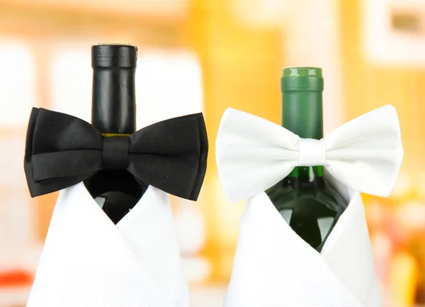 Corbatas de lazo blancas y negras en botellas de vino sobre fondo brillante —  Fotos de Stock