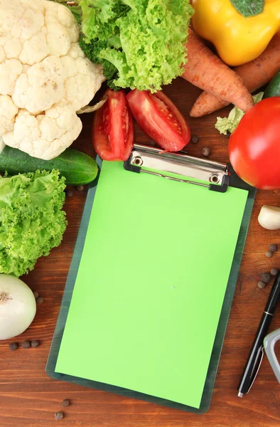 Verduras frescas y especias y papel para notas, sobre fondo de madera — Foto de Stock