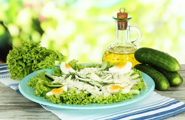 Вкусный салат с яйцами, капустой и огурцами на деревянном столе — стоковое фото