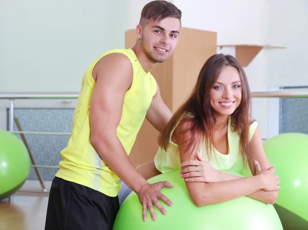 Menina e treinador envolvidos na sala de fitness — Fotografia de Stock