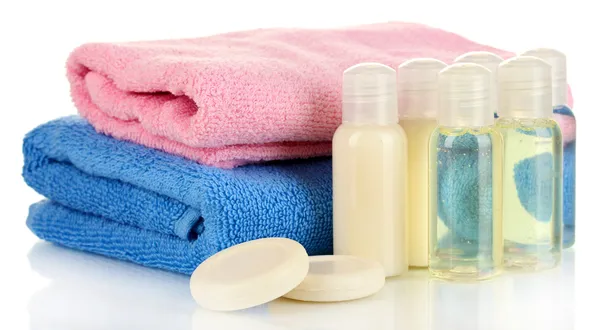 Bottiglie cosmetiche hotel con asciugamano isolato su bianco — Foto Stock