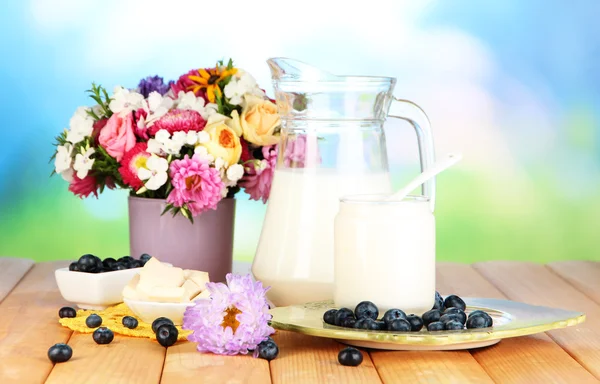 Čerstvé mléčné výrobky s borůvkovým na dřevěný stůl na přírodní pozadí — Stock fotografie