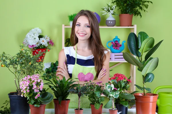 Vacker flicka florist med blommor i rummet — Stockfoto