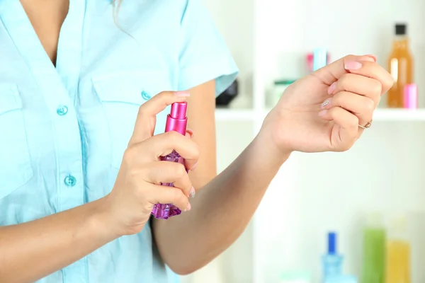 Woman testing perfume on shop windows background — Stock Photo, Image