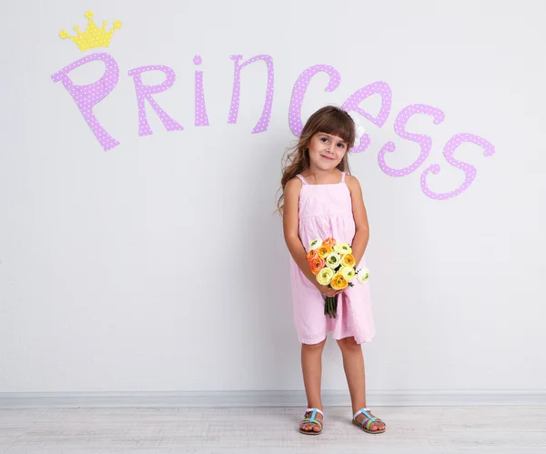 Little girl posing on grey wall background — Stock Photo, Image