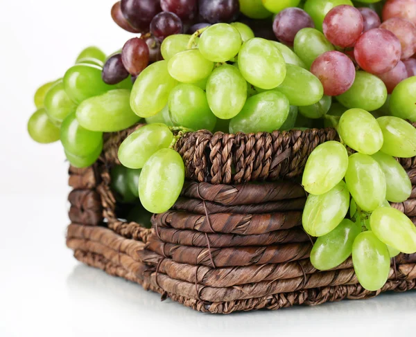 Uvas verdes e roxas maduras em cesta isoladas a branco — Fotografia de Stock