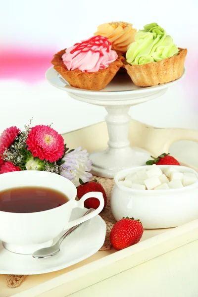 Taza de té con pasteles en bandeja de madera en la mesa en la habitación — Foto de Stock