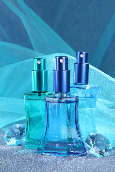 Женщины духи в красивых бутылках на голубом фоне — стоковое фото