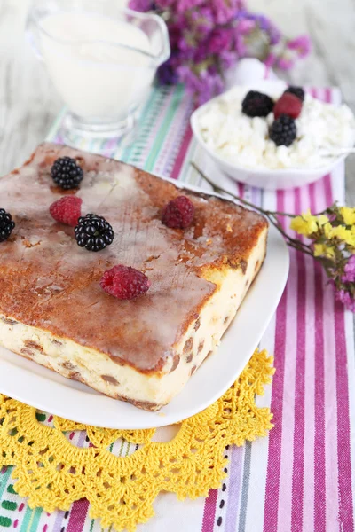 Cheese casserole with raisins on plate on napkin on wooden table close-up — Stock Photo, Image