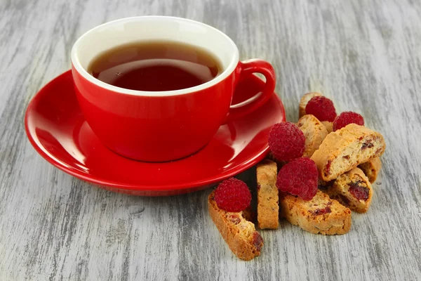 Kopje thee met koekjes en frambozen op tabel close-up — Stockfoto