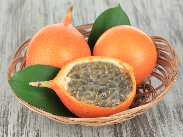 Passion fruits in wicker basket on table close-up — Stock Photo, Image