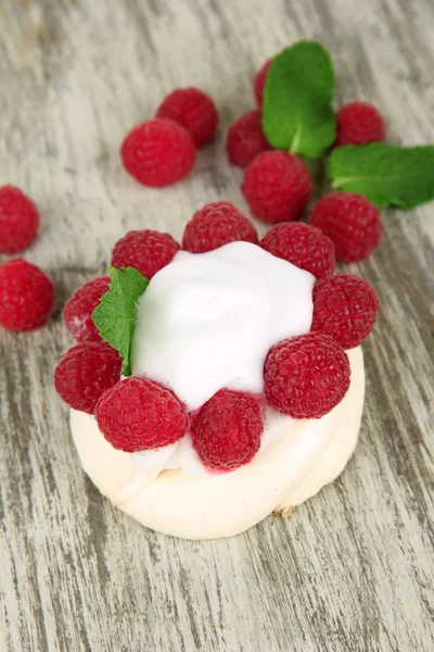 Bolo de merengue saboroso com bagas na mesa de madeira — Fotografia de Stock