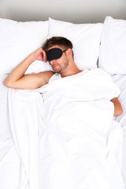 Yakışıklı genç adam yatakta.