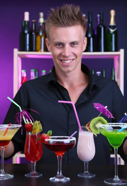 Portrait of handsome barman with different cocktails cocktail, at bar — Stock Photo, Image