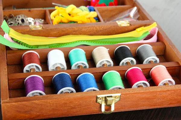 Швейний комплект в дерев'яній коробці на дерев'яному столі — стокове фото