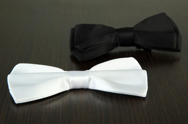 Black and white bow ties on wooden background — Stock Photo, Image