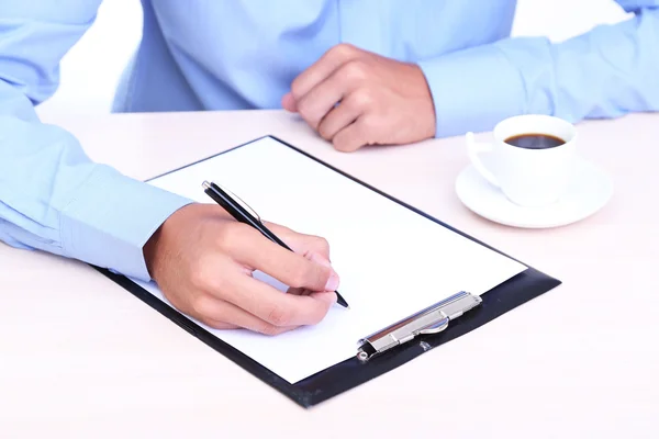 Businessman writing on document in office close-up — Stock Photo, Image