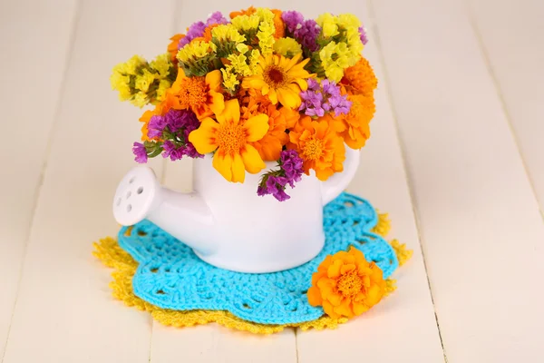 Bouquet of marigold flowers in watering can on wooden table close-up — Stock Photo, Image