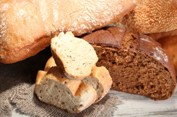 Veel brood op rouwgewaad op houten bord — Stockfoto