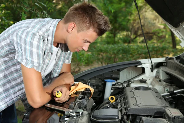 Jeune conducteur réparant moteur de voiture à l'extérieur — Photo