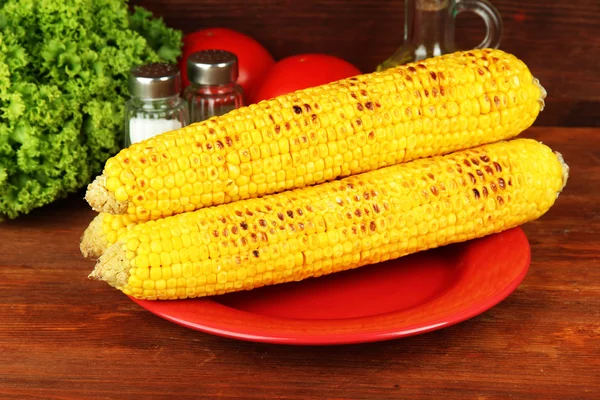 Delicioso maíz dorado a la parrilla en la mesa sobre fondo de madera — Foto de Stock