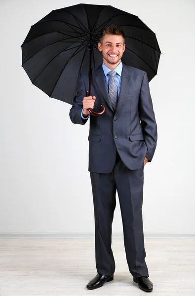 Businessman with umbrella. on gray background — Stock Photo, Image