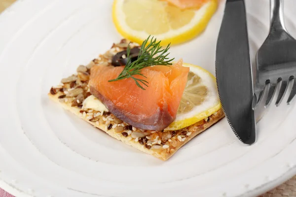 Salmon sandwich on plate on wooden table close-up — Stock Photo, Image