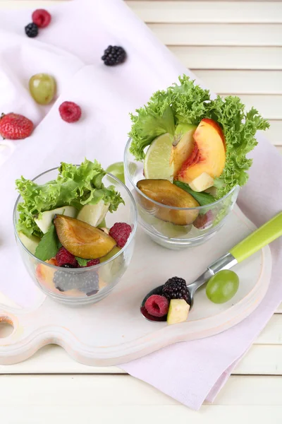 Salada de frutas em copos, no fundo de madeira — Fotografia de Stock