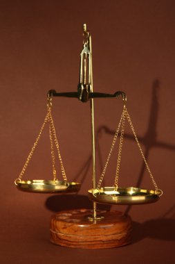 Adaletin kahverengi zemin üzerine altın terazisi