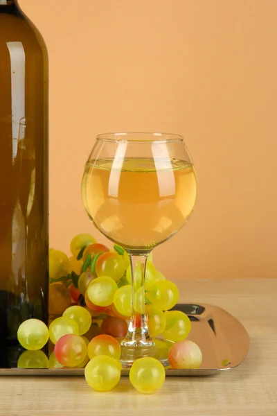 Weißwein im Glas mit Flasche auf Salver auf beigem Hintergrund — Stockfoto