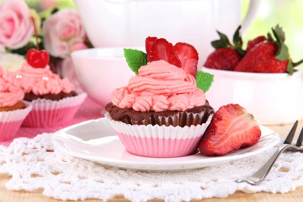 Beautiful strawberry cupcakes on dining table close-up