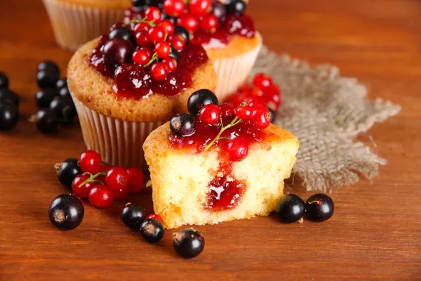Chutné muffiny s ovocem na dřevěný stůl — Stock fotografie