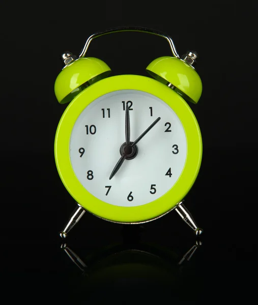 Green alarm clock on dark grey background — Stock Photo, Image