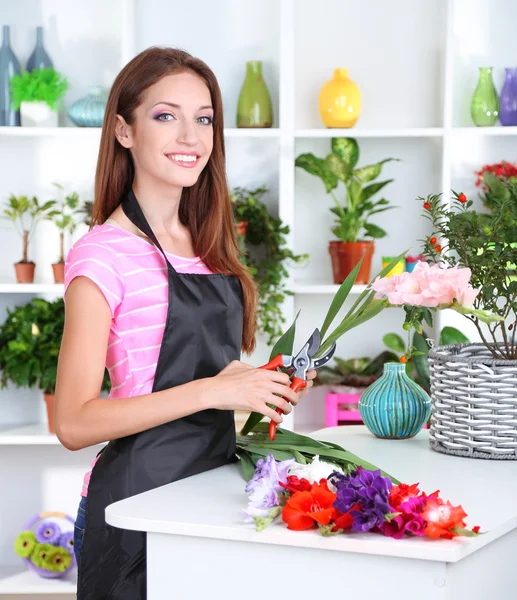 Linda florista menina com flores na loja de flores — Fotografia de Stock