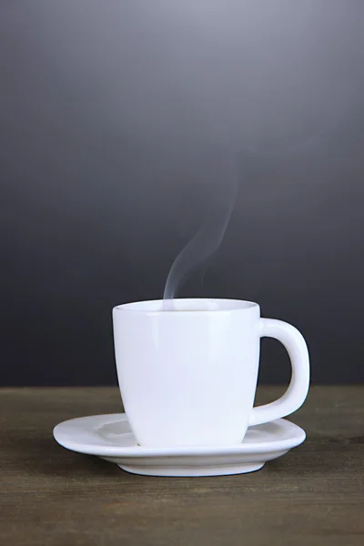 Tazza di caffè su tavolo di legno su sfondo nero — Foto Stock