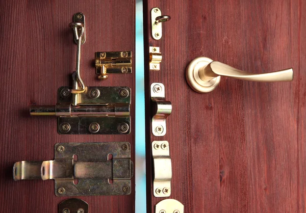 Parafusos metálicos, travas e ganchos em porta aberta de madeira close-up — Fotografia de Stock