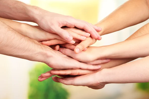 United hands on bright background. Conceptual photo of teamwork — Stock Photo, Image